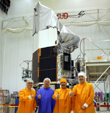 <b>Fig.6:</b> The HERSCHEL satellite in the cleanroom of the test facility S1B of Europe's space port in Kourou, French Guiana. In front of the satellite, the PACS test team gives green light for launch after a last successful functional test of the instrument.